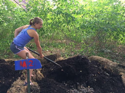 Student working with a compost pile