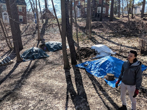 Compost piles covered with tarps during cold weather