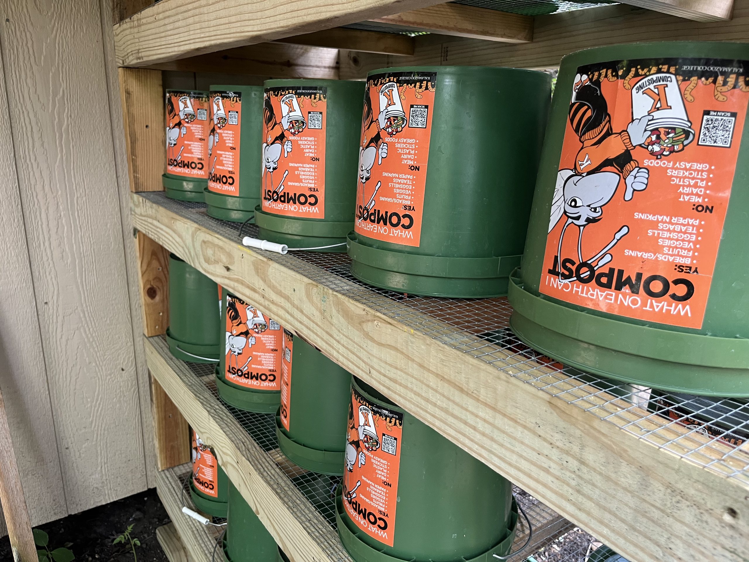 Close up of green buckets upside down with orange labels on shelves