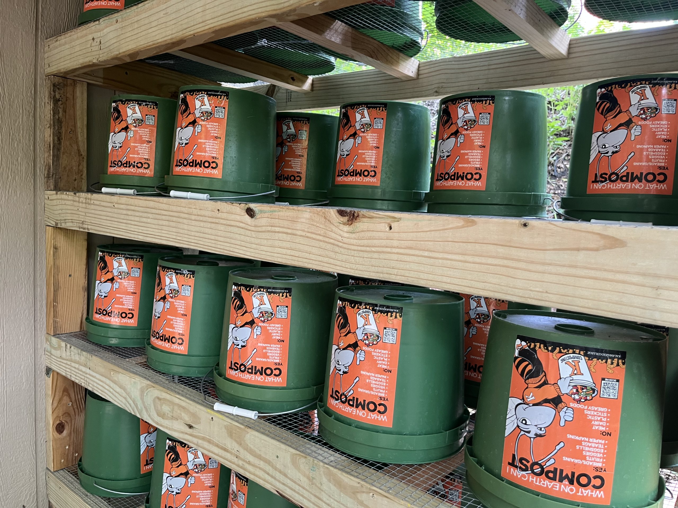 Close up of green buckets upside down with orange labels on shelves