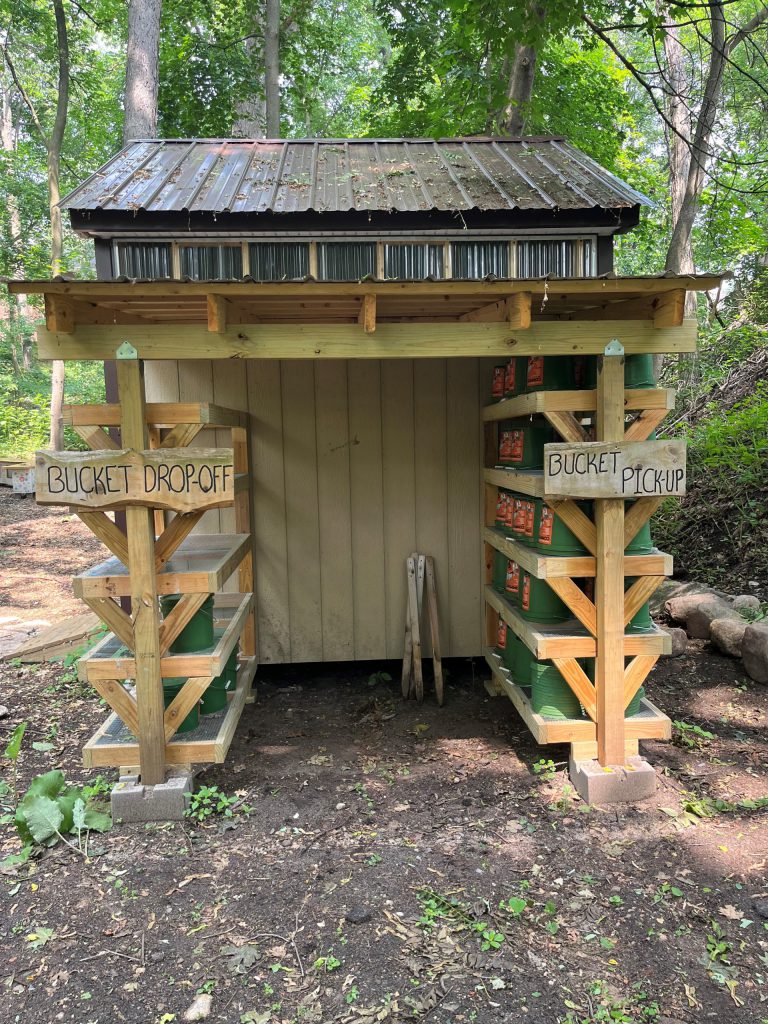 Composting shed bucket pick up and drop off